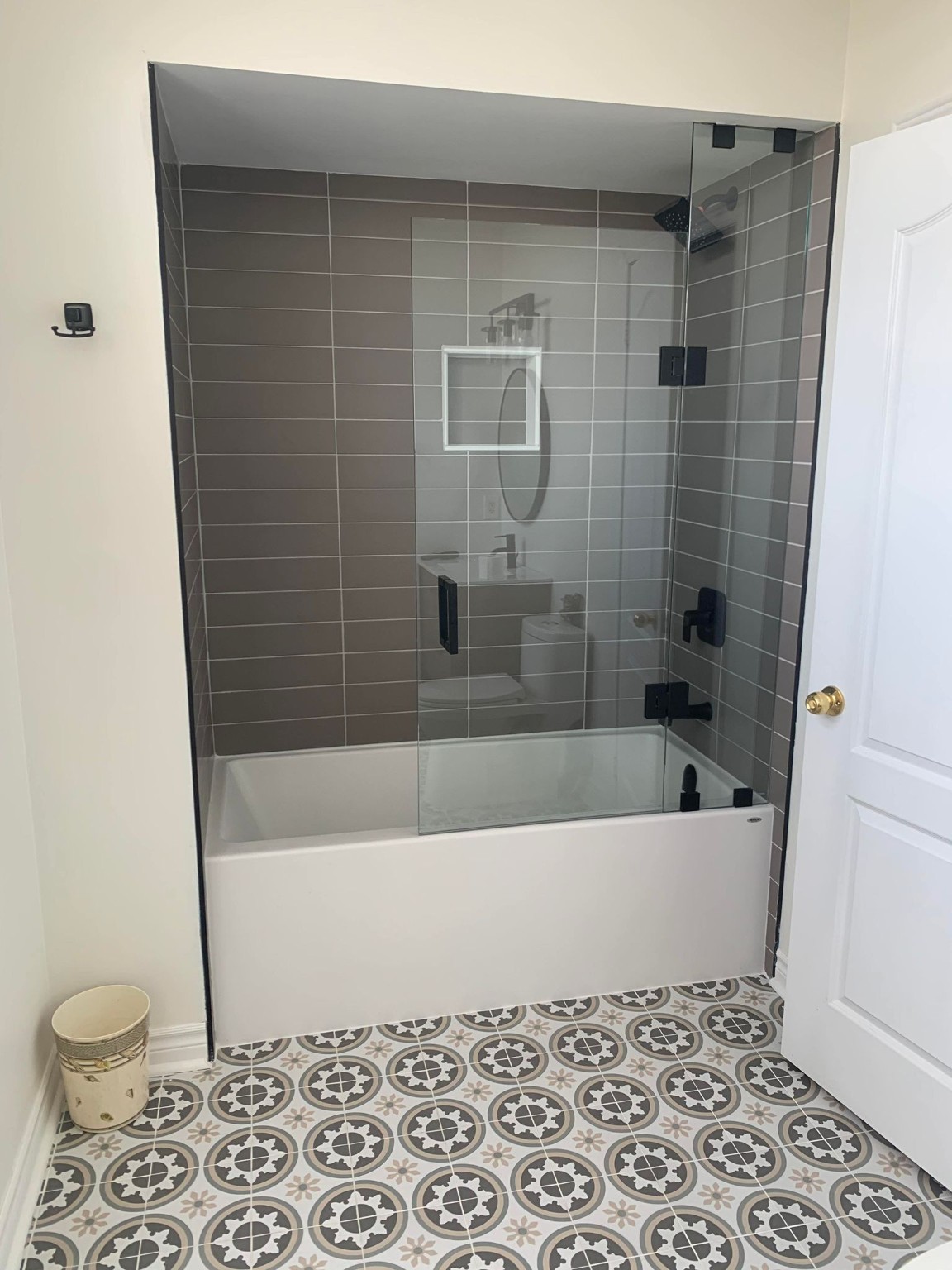 Completed bathroom renovation with patterned floor tile by AMN Group Inc.